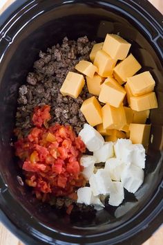 cubed cheese, diced tomatoes and ground beef in a slow cooker bowl