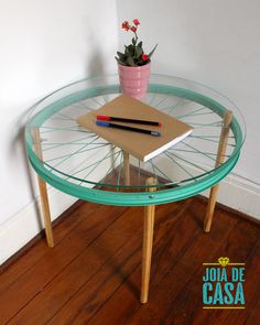 a glass table with some books and a potted plant on it in the corner