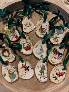 twelve decorated cookies in the shape of spoons with green ribbons and bows on them