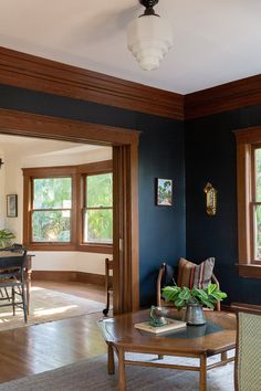 a living room with blue walls and wood trim around the windows is pictured in this image