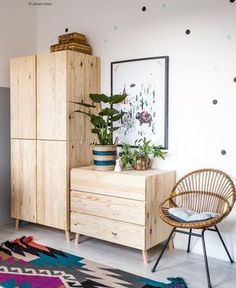 a room with some plants on top of it and a chair in front of the dresser