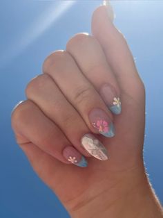 a woman's hand with flowers painted on it and blue sky in the background