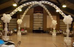 an indoor event with clear balloons and white table cloths on the floor, along with chairs