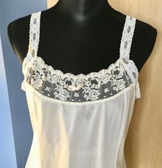 "This white nylon slip by Greenco Maid has lace straps and neckline. There is also lace trim at the hem. The straps are elastic lace but not adjustable. It is a size 38 with these measurements: Bust: 38\" Waist: 36\" Hips: 46\" Shoulder to hem: 40\" Strap length: 6\" Our items are in good condition. Should there be undue wear, something missing or inoperable it will be noted in our text and there will be a photo highlighting such. We add new items regularly and appreciate you taking a look." White Camisole With Contrast Lace For Summer, White Contrast Lace Camisole For Summer, Summer Lace Camisole With Contrast Lace, White Camisole With Contrast Lace, White Lace Contrast Camisole, White Contrast Lace Cami Camisole, White Contrast Lace Camisole, White Lace Camisole With Straps, Daywear Camisole With Contrast Lace And Spaghetti Straps