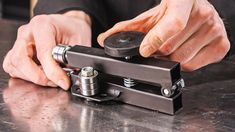 a man is working on a metal object with one hand and the other holding it