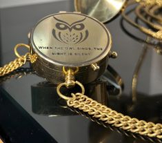 a close up of a chain on top of a table with an owl charm attached to it