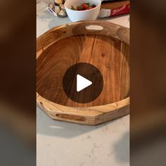 a wooden bowl sitting on top of a counter next to a bowl filled with strawberries