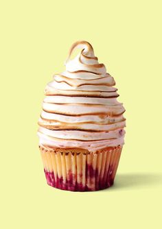 a cupcake with white frosting on a yellow background