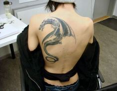 a woman with a dragon tattoo on her back