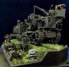 a model of an old steam engine on display with grass and rocks in the foreground