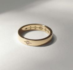 a close up of a ring on a white surface with a star in the middle