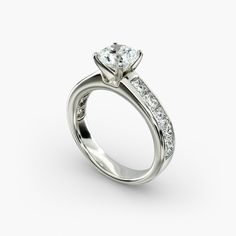 a white gold engagement ring with channeled diamonds on the sides and a side stone in the center