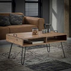 a coffee table with hairpin legs in front of a brown couch and black blinds