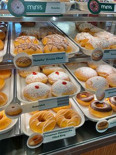 a display case filled with lots of different kinds of doughnuts and pastries