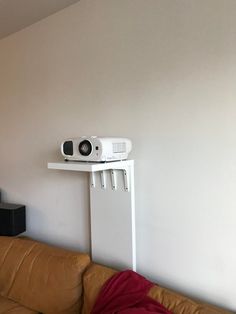 a living room with a couch and a projector on top of the tv stand