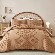 a bed in a room with a brown comforter and pillows