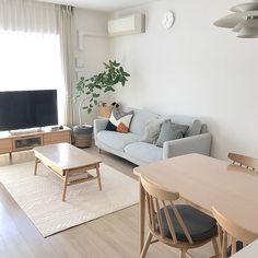 a living room filled with furniture and a flat screen tv sitting on top of a wooden table