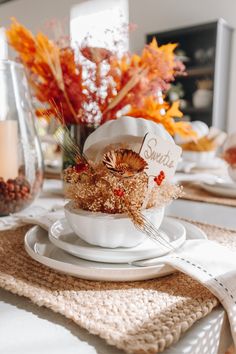 a white bowl filled with food sitting on top of a plate next to an orange vase