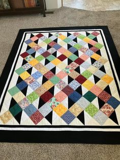 a multicolored quilt on the floor in a room