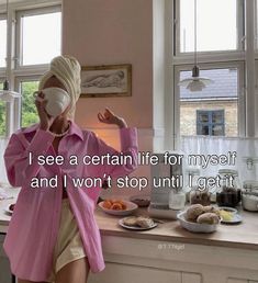 a woman wearing a blindfold standing in front of a kitchen counter with food on it