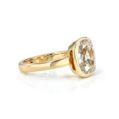 a yellow gold ring with an oval cut diamond