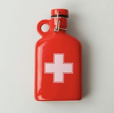 a red flask with a white cross on the front is hanging from a hook