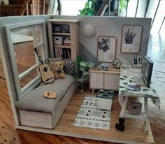 a doll house with furniture and decorations on the floor, including a couch in front of a window