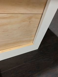 a close up of a wooden cabinet door on a wood flooring area with dark floors