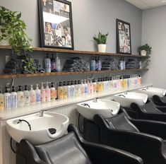 a row of black chairs sitting next to each other in front of a wall filled with bottles