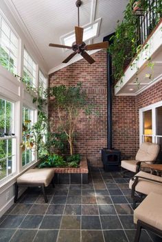 an indoor living room with brick walls and ceiling fan