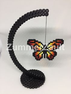 the beaded butterfly is hanging on a string and it's made out of beads