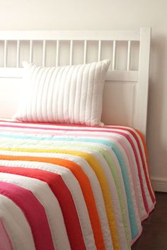 a bed with a multicolored quilt on it