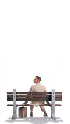 a man sitting on top of a wooden bench