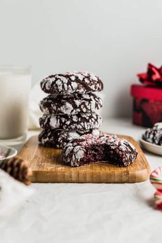 chocolate crinkle cookies stacked on top of each other next to a glass of milk