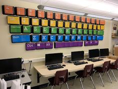 a classroom with desks and computers on the wall