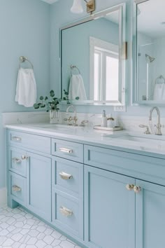 a bathroom with blue cabinets and mirrors