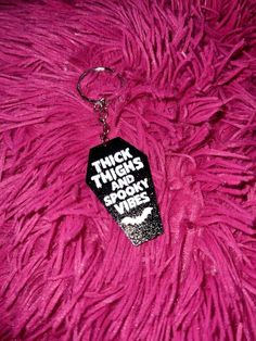 a black and white keychain that says think things are wrong on pink fur