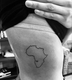 a woman's back with a small outline of africa on it