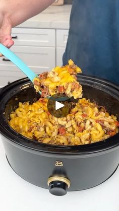 a person scooping food out of a slow cooker