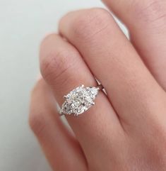 a woman's hand with a diamond ring on it