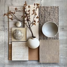 an arrangement of vases, bowls and other items on a wooden table with grey wallpaper