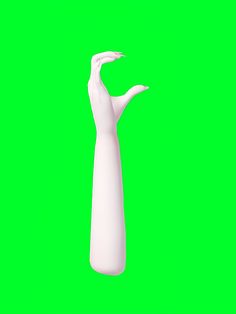 a tall white vase sitting on top of a green surface