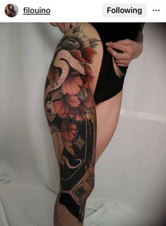 a woman's leg with tattoos on it and an image of flowers in the background