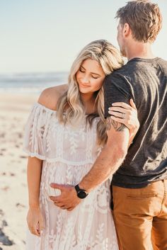 a man and woman embracing on the beach