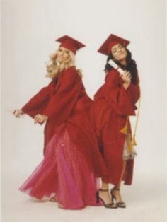 two women in red graduation gowns posing for the camera