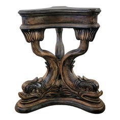 an ornate wooden table with carved designs on the top and bottom, against a white background