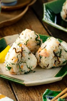 rice balls on a plate with chopsticks next to it