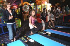 children and adults playing in an indoor pinball game