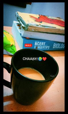 a cup of coffee sitting on top of a wooden table