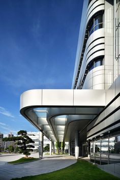 an architectural building with grass and blue sky in the background